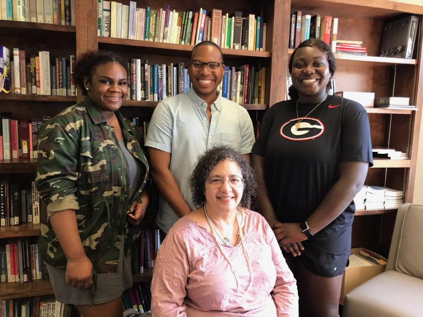 A couple of students posing with the director of the department