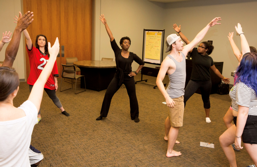 A professor with students doing some warmup exercises 